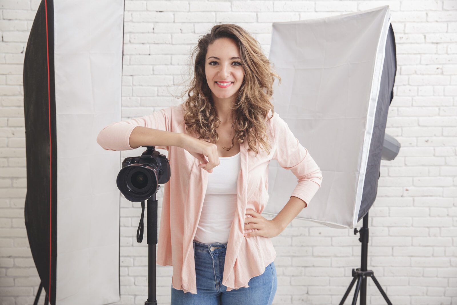 portrait of Young female photographer with camera in professionally equipped studio