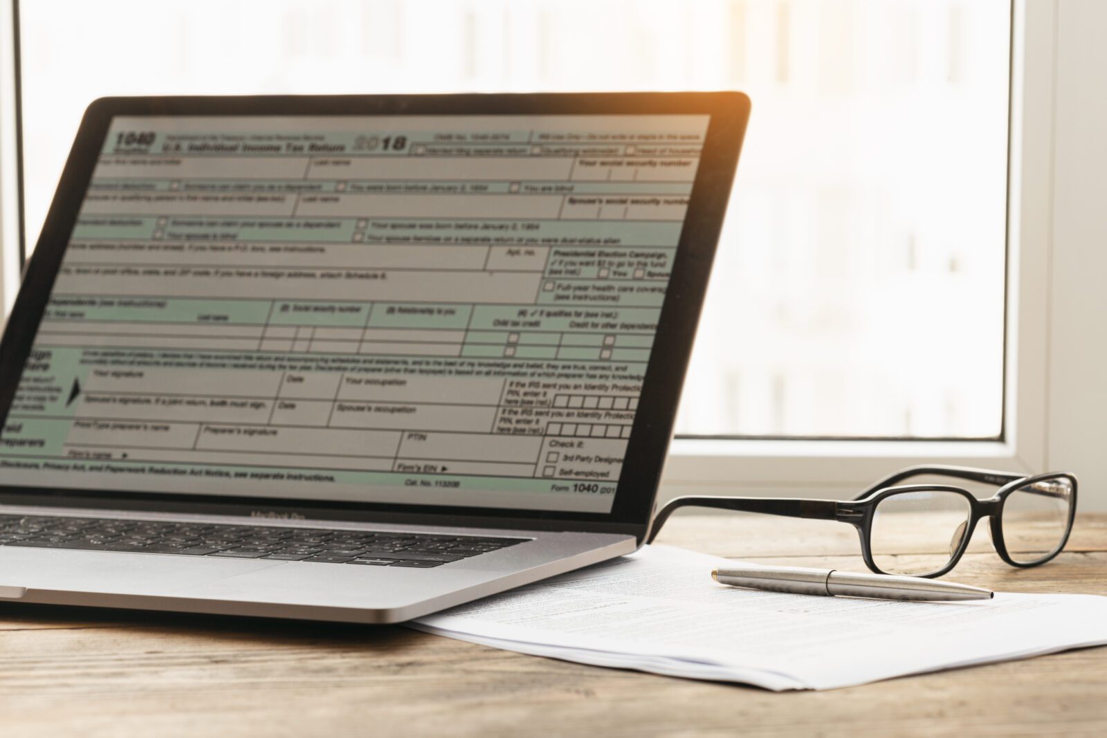 Tax planning. Laptop with form individual income tax returns