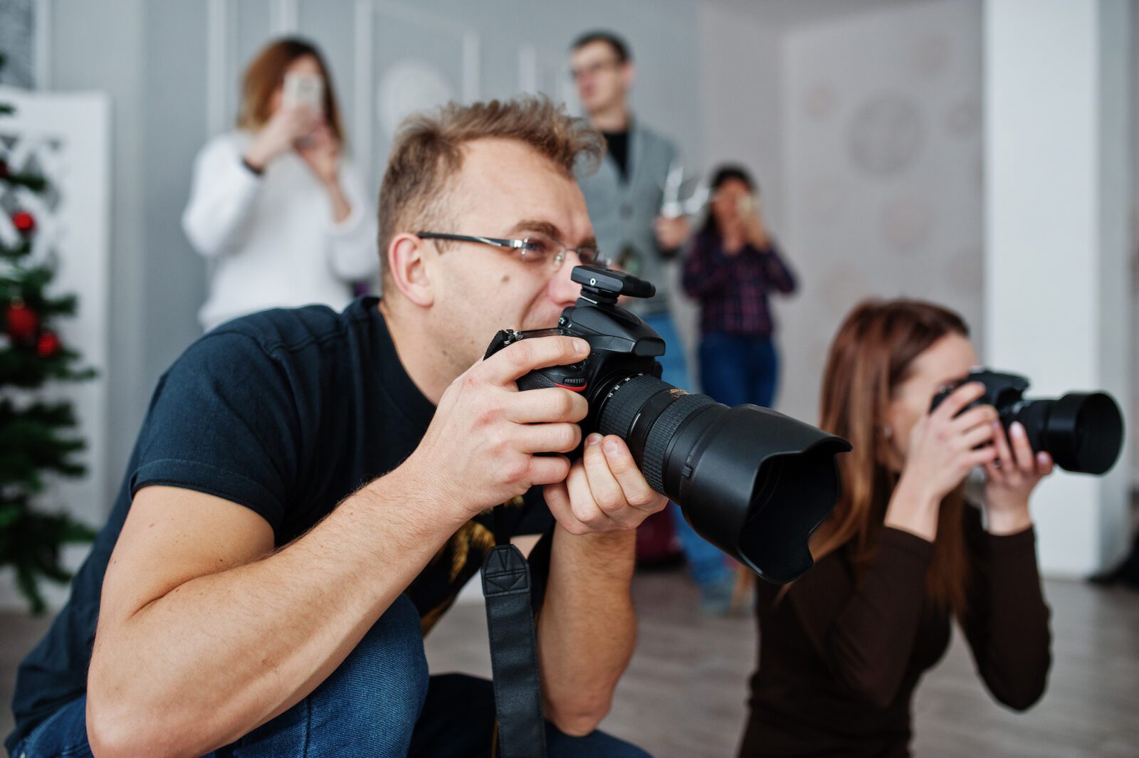 Photographer preparing camera equipment for a professional photo shoot, highlighting growth in a photography business.