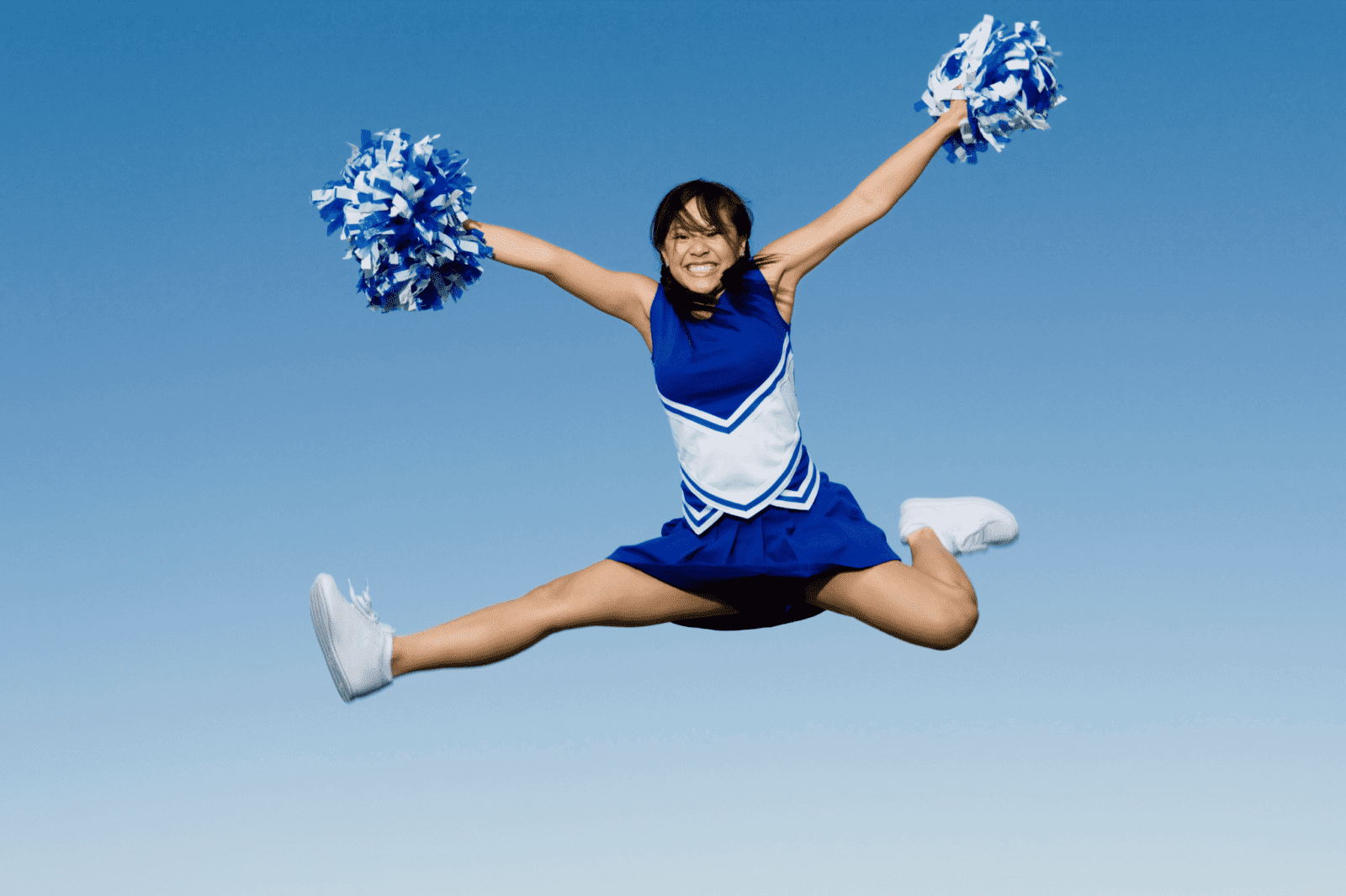 A cheerleader performing a jump during a cheerleading action shot