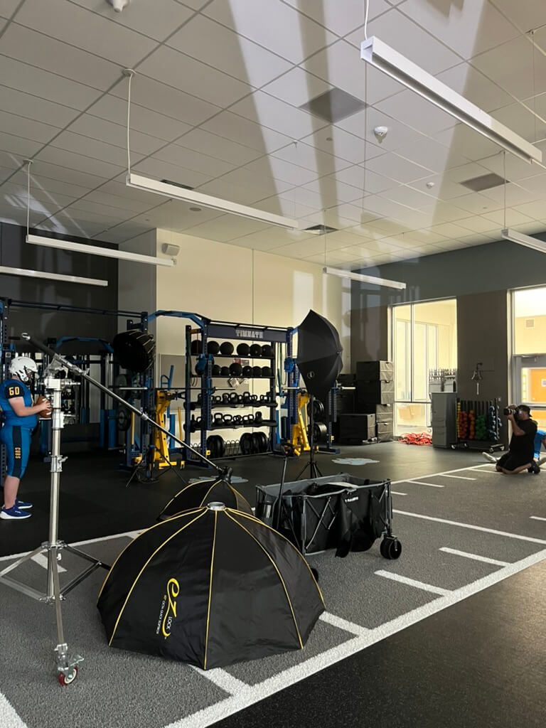 Black Iron Photography photo shoot of a football player in a school weight room