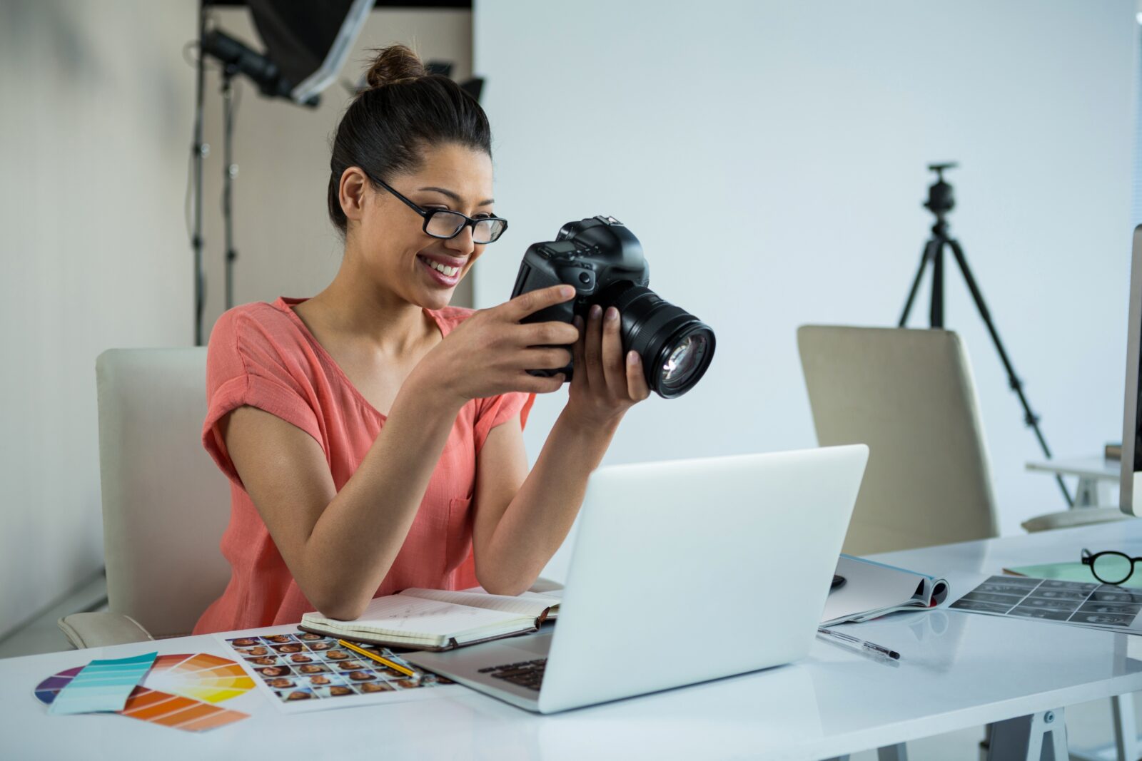 Woman smiling at camera, working on laptop