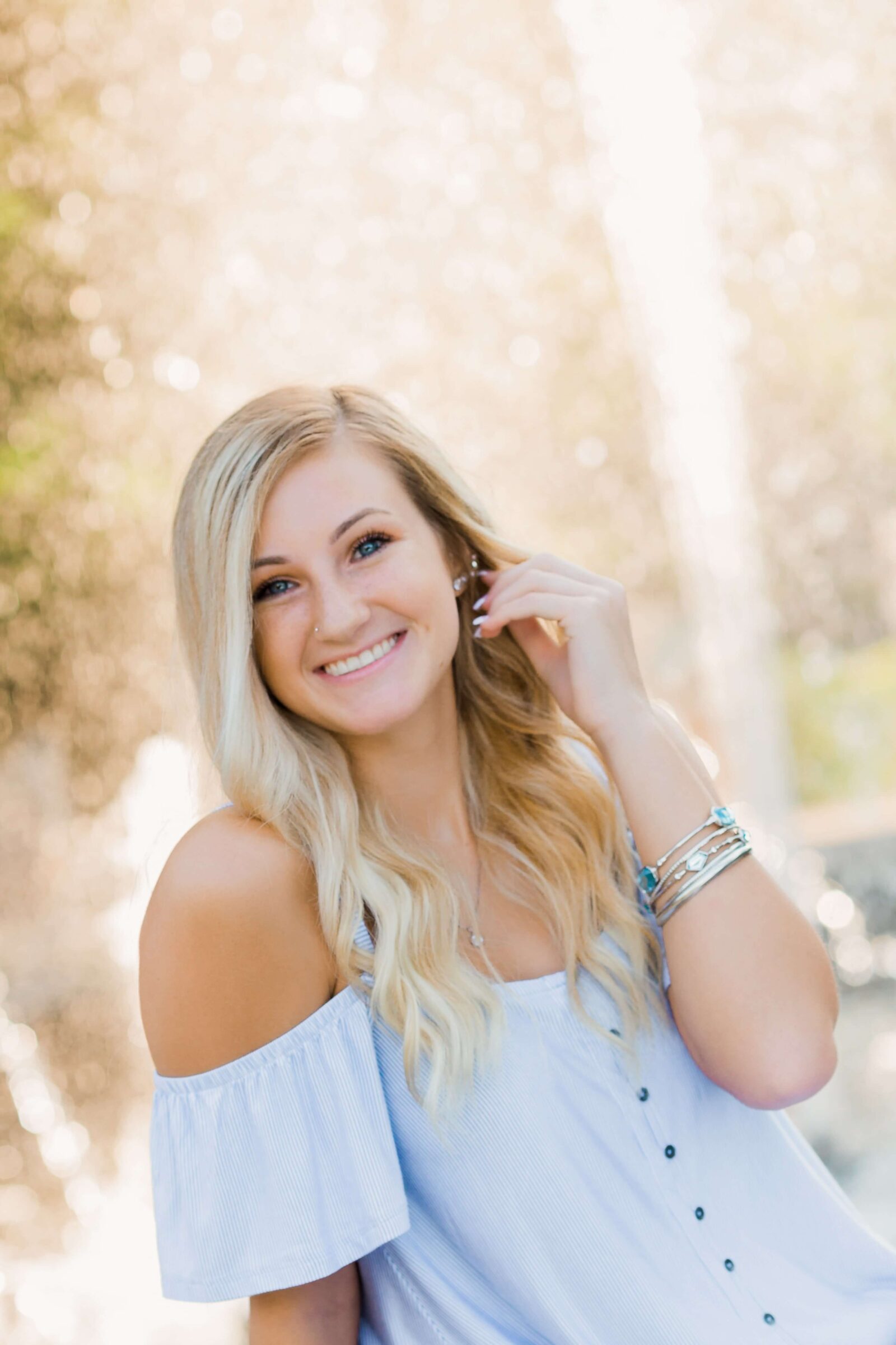 A high school senior poses outside for her senior portrait