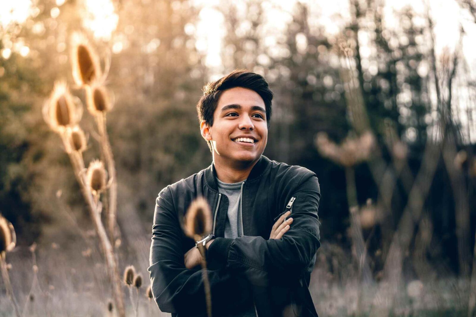 A man poses in a field demonstrating natural lighting and golden hour for outdoor portraits